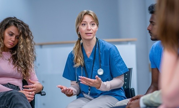 A group of nurses sit and discuss.