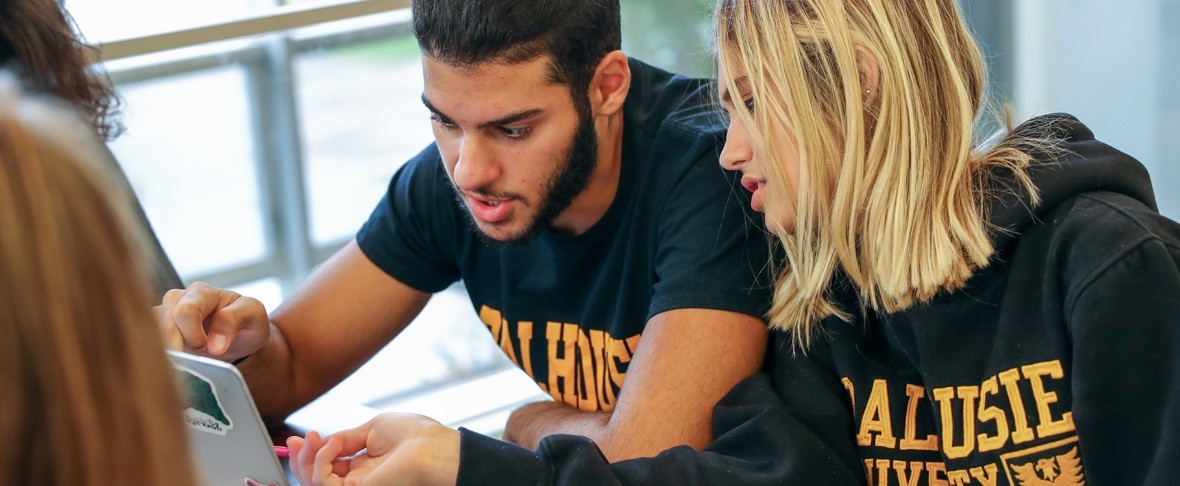 Dalhousie students gathered around a laptop