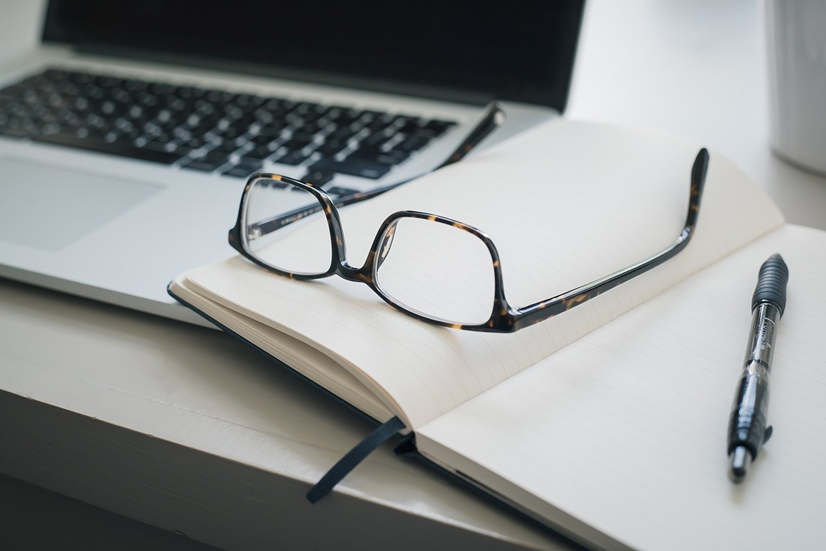 Glasses and laptop on desk