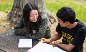 Two students studying outside at a picnic table
