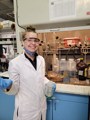 Breanna Taylor, 3rd year chemistry student stops to smile while purifying her organic compound via column chromatography.