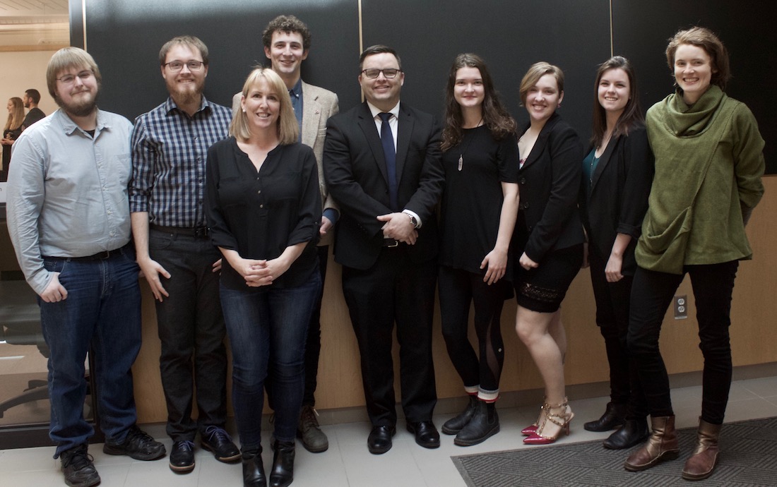 A group of ESS Capstone participants (students and community clients) stand together and smile at the camera.