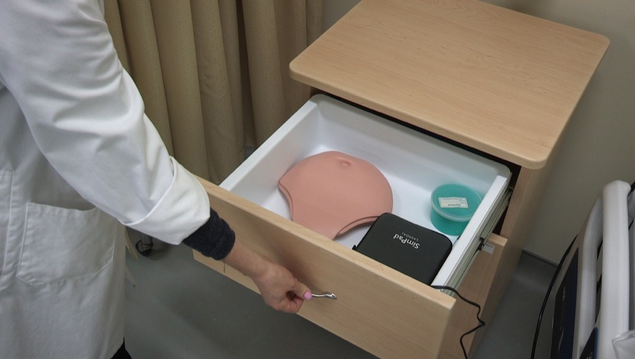 Professor opening drawer to show mannequin parts