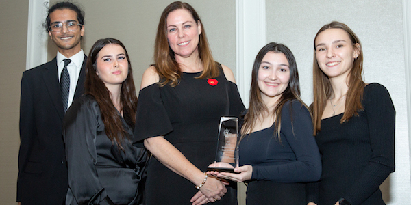 The Guelph-Humber team poses with a Scotiabank representative, holding a trophy.