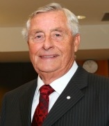 Ken Rowe wearing a suit and tie, smiling at the camera. 