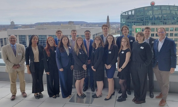 Dr. Sundararajan poses with a group of students. The Ottawa skyline is visible behind them.