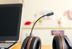 Laptop with a microphone and headset placed beside it.