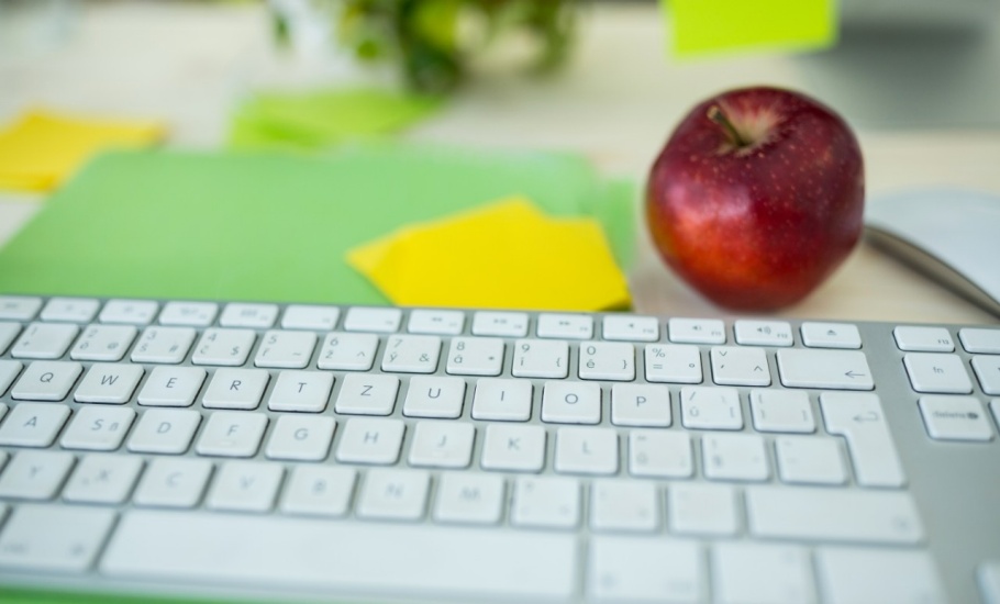 keyboard and an apple on a desk