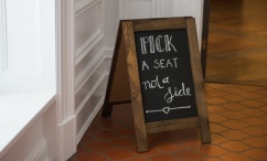'Pick a seat not a side' written on chalkboard