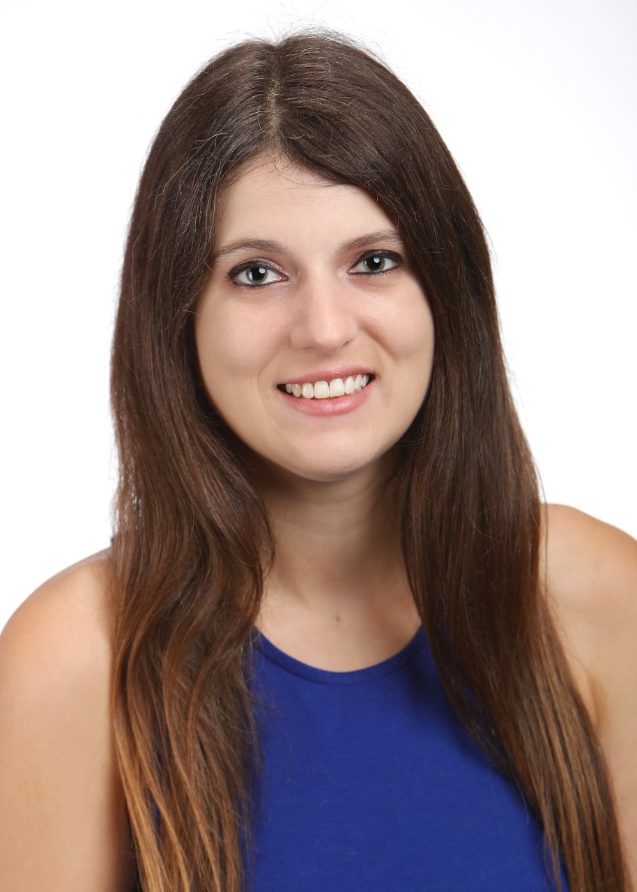 Photo of Kaitlynne Lowe, long brown hair and blue dress on white background