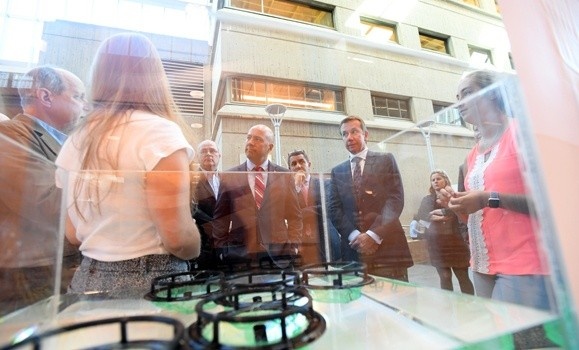 A crowd of people gathering around a research demonstration inside of a Dalhousie building during a DeepSense  announcement event.