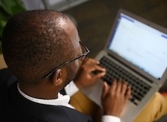 Image over shoulder of man working on computer