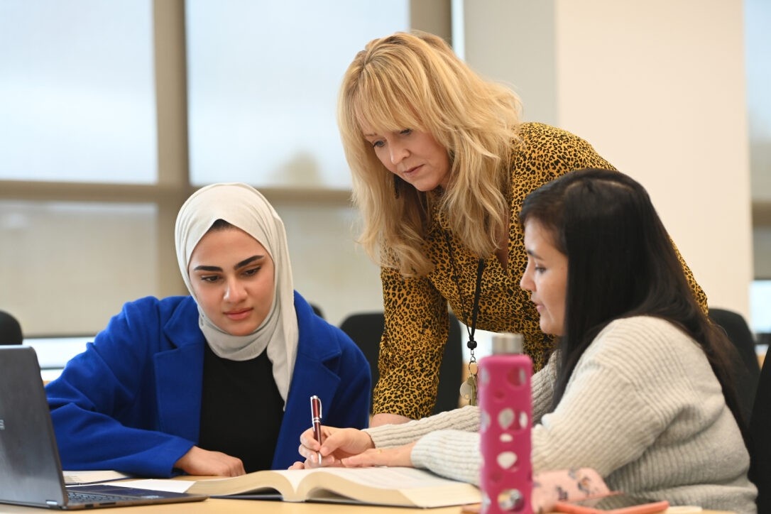 two students studying with faculty help