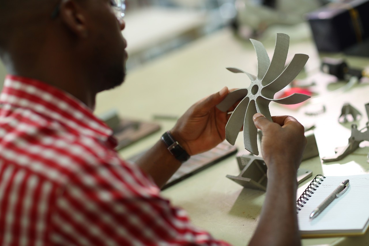 Student participating in co-op work holding and examining an object