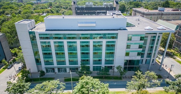The Rowe Building is shown from above. It is a concrete L-shape with tinted green windows and is surrounded by trees. The Rowe Building is shown from above. It is a concrete L-shape with tinted green windows and is surrounded by trees.