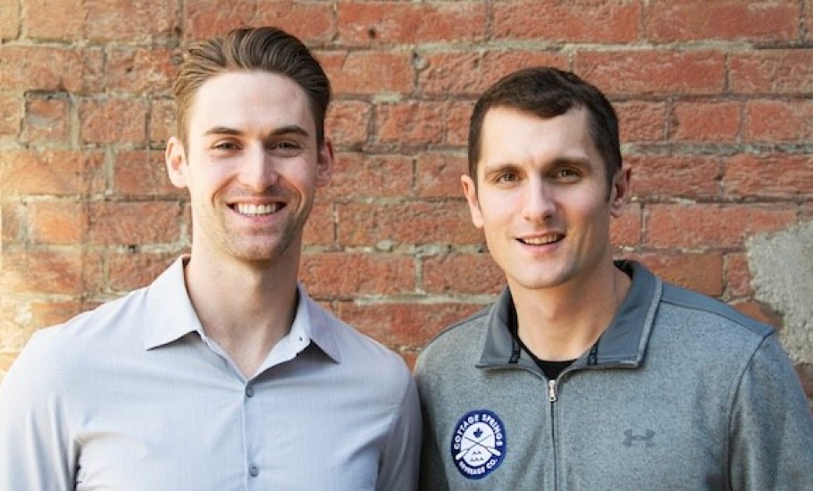 Cam McDonald and Daniel Bartek smile in front of a brick wall.