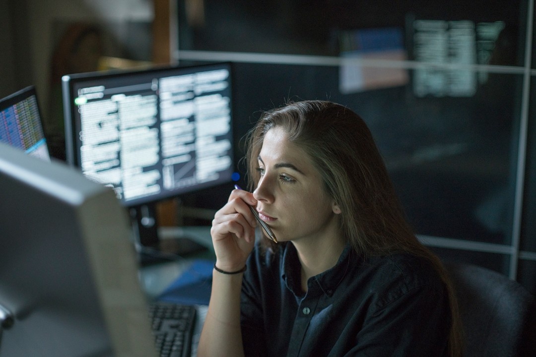 Student looking at multiple screens contemplating.