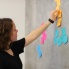 Woman moves sticky notes off wall in learning exercise.