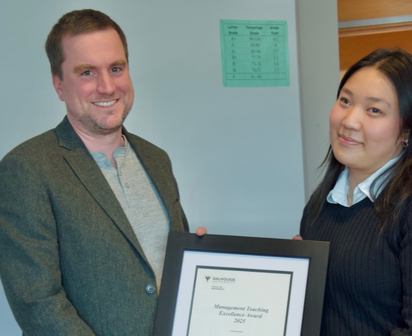 Dr. Bennett and Janet hold a teaching certificate between them, smiling.