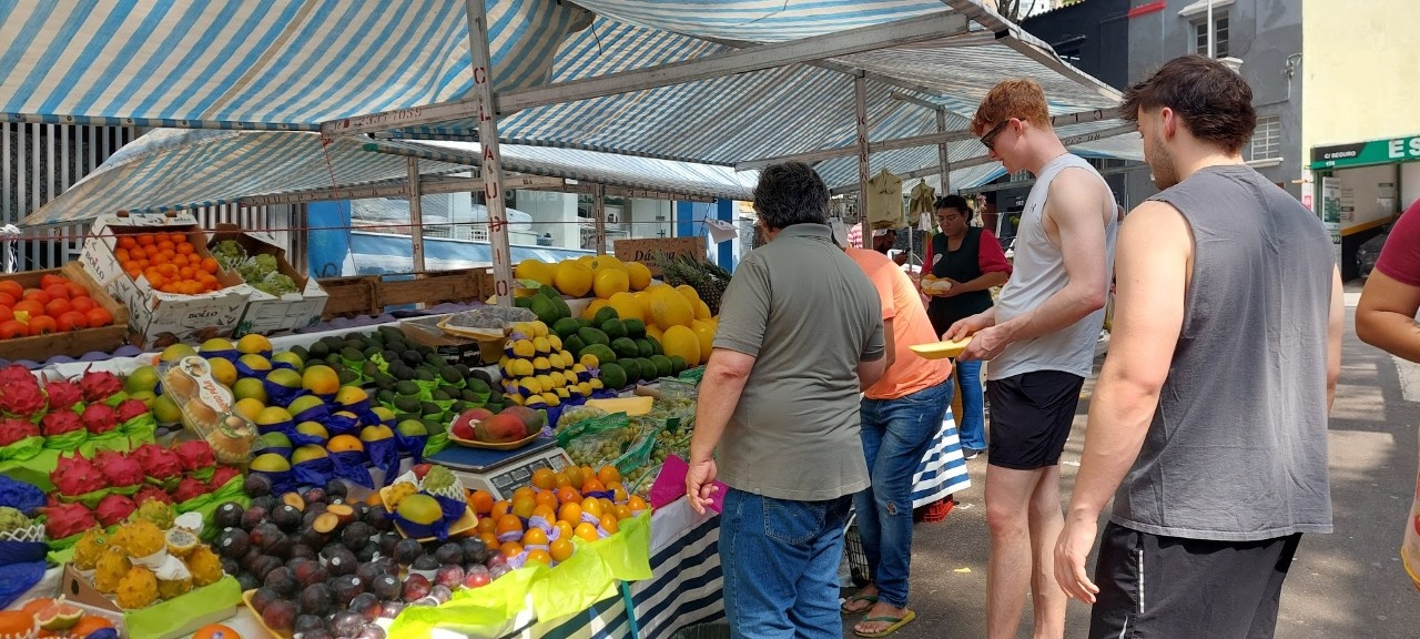 Students look at produce in a market.