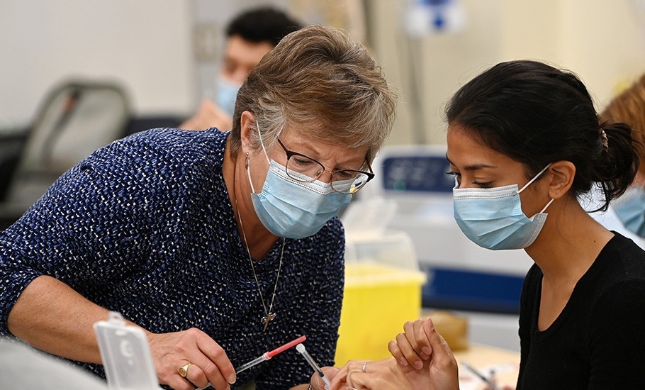 A doctor demonstrates technique for a student