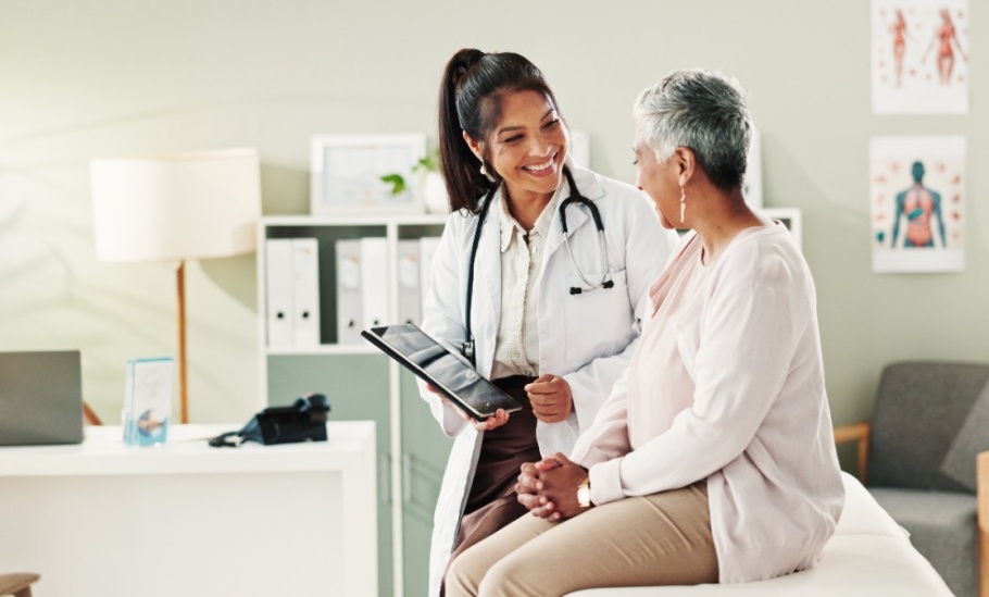 Mature patient, doctor and tablet for healthcare, support or conversation with checkup appointment in office. Female person, medical professional and diagnosis talk for senior woman at clinic