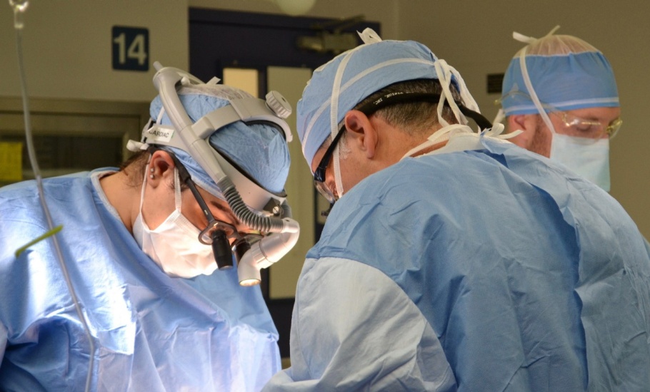 Three doctors operating on a patient