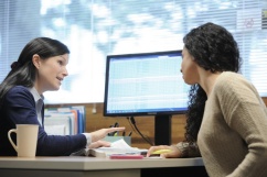 2 people sit in front of a computer in a meeting