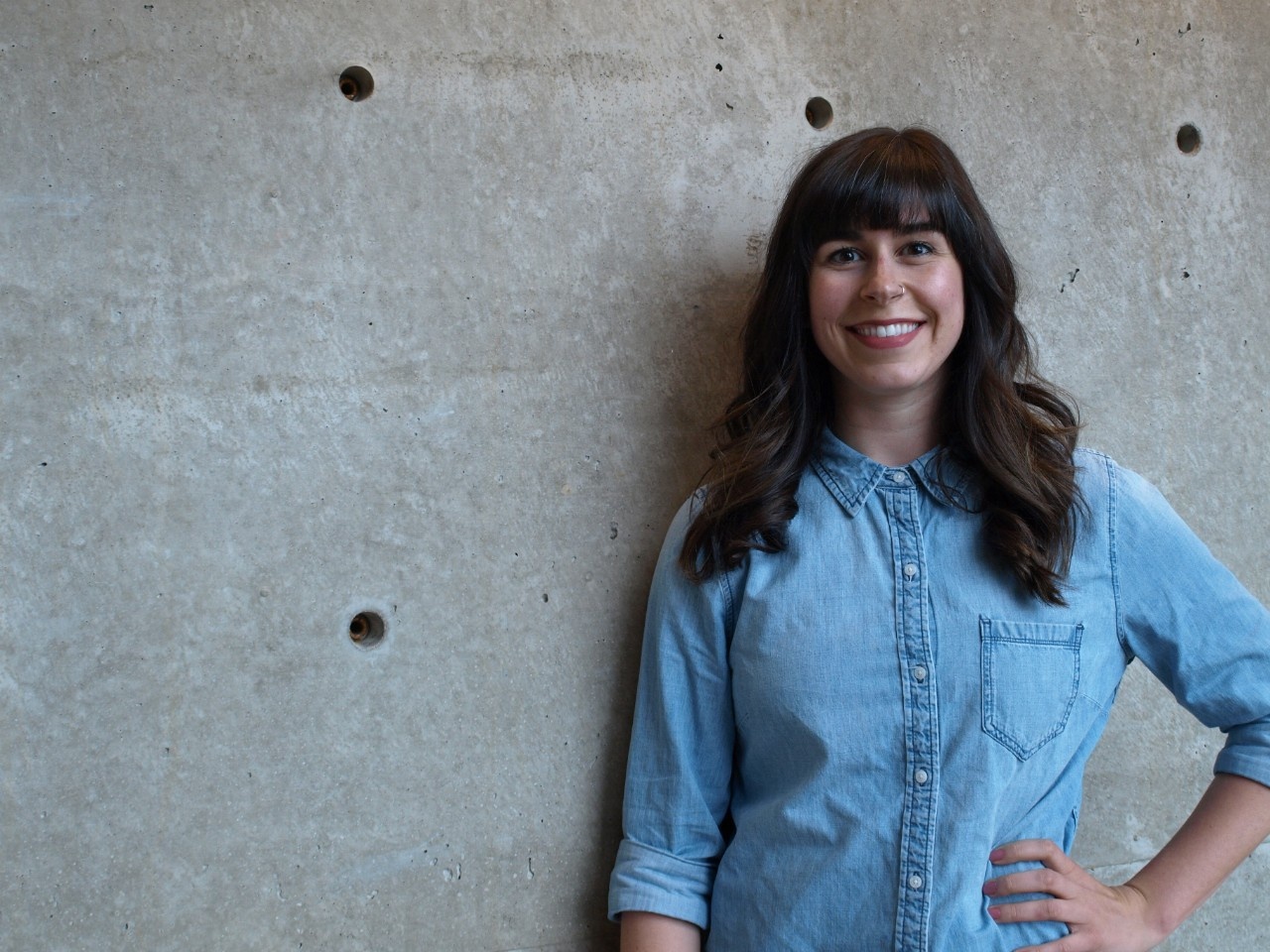 Laurel smiles at the camera. She has a light skin tone and long, dark brown hair.