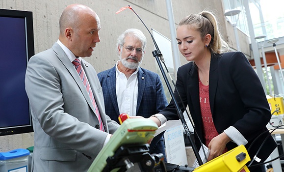 Research Assistant Fiona Henderson with Grant Wach, explaining a project component to MP Andy Fillmore (left). (Nick Pearce photos, except where indicated) Research Assistant Fiona Henderson with Grant Wach, explaining a project component to MP Andy Fillmore (left). (Nick Pearce photos, except where indicated)
