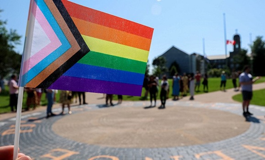 An individual holds a small Pride flag as the event gets underway.