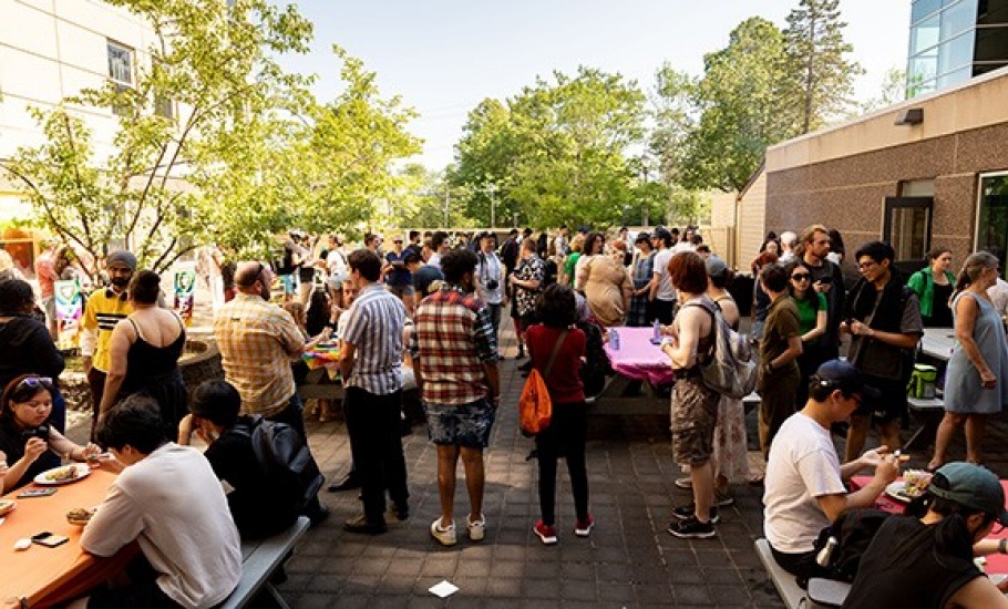 Individuals gathered in the Risley Hall quad for the BBQ.