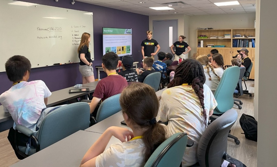 A group of children watching a presentation about the Share the Road campaign