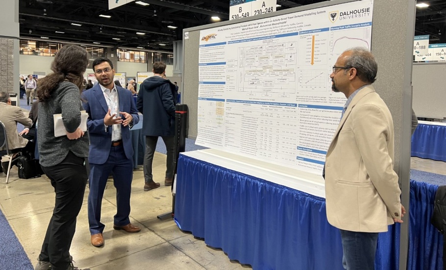 A man presenting his research poster to an observer