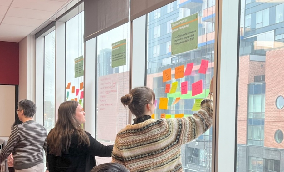 A woman placing her planning idea on a sticky note on the wall