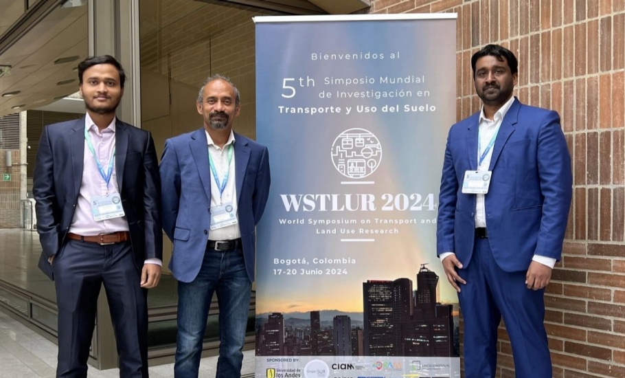 A group of three men posing in front of the WSTLUR conference banner