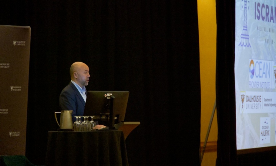 A man giving a presentation standing at a podium