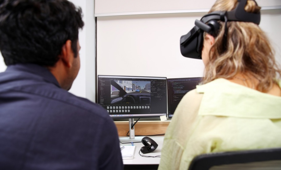 A Student wearing VR goggles while trying out the driving simulator
