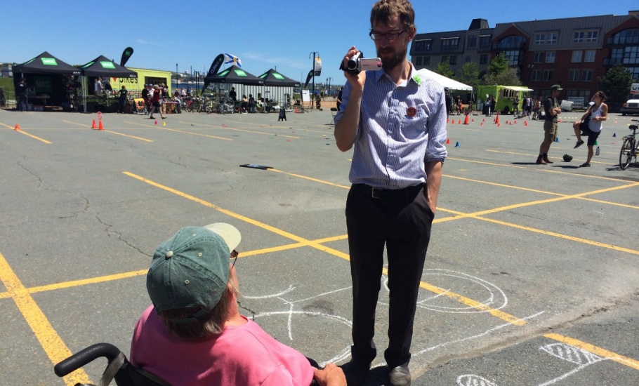 A man filming an interview with a person in a wheelchair