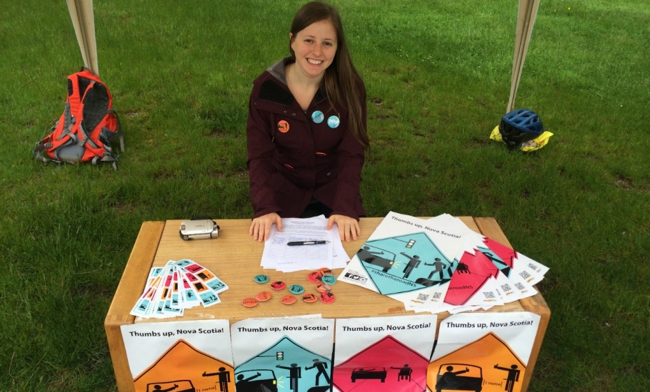 A woman sitting at a table with road safety promotional material on it