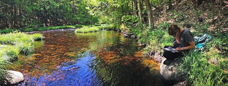 Student on a river bank