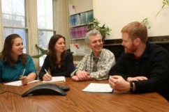 Students and faculty meet in a conference room