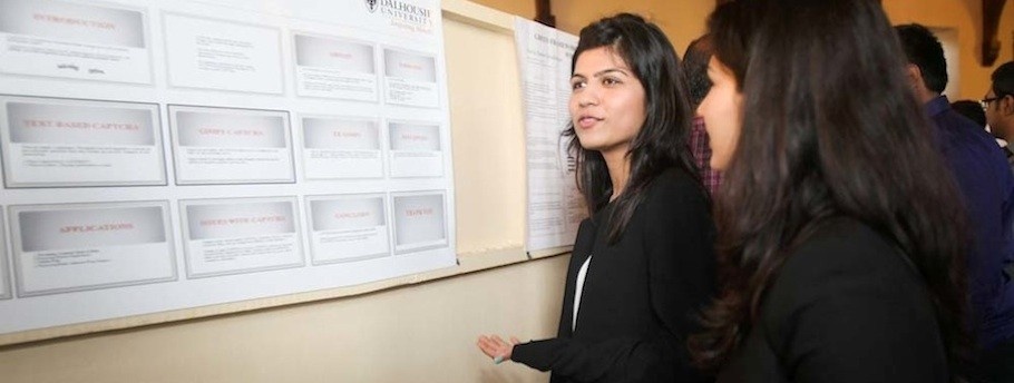 Two female students discuss their research at the seminar.