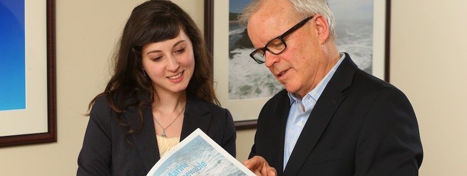 Melissa and her supervisor standing in an office examining a document.